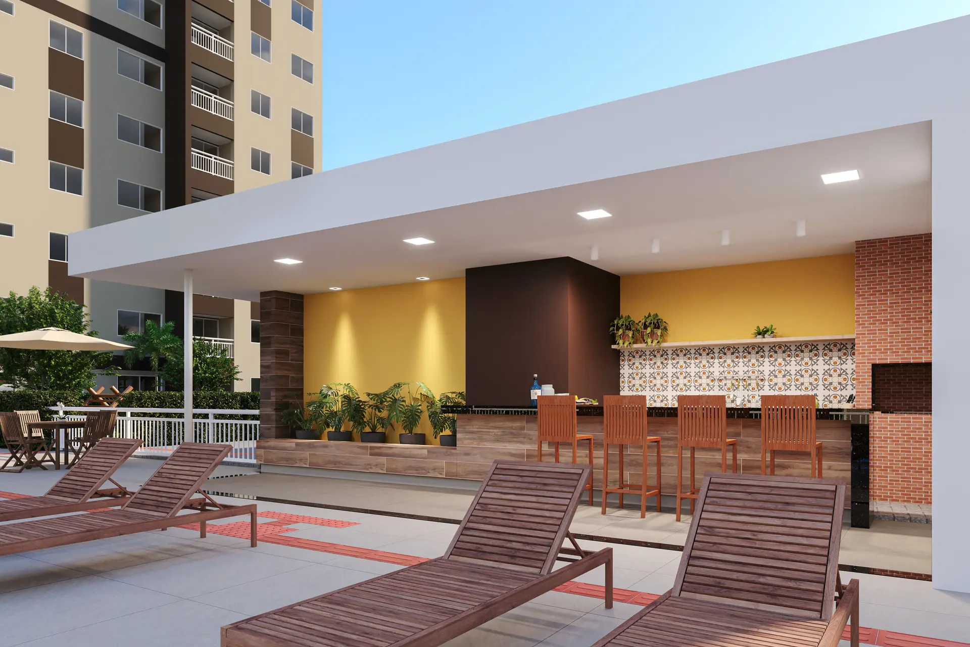 Deck da piscina do empreendimento ao entardecer, com espreguiçadeiras e espaço gourmet